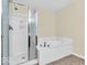 Bright bathroom featuring a tub and shower with glass doors, and tile flooring at 11936 Esty Way, Carmel, IN 46033