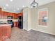 Cozy kitchen with dark wood cabinetry, modern appliances, tile floor and a chandelier at 11936 Esty Way, Carmel, IN 46033