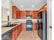 Well-equipped kitchen featuring wood cabinets, tile flooring, and modern black appliances at 11936 Esty Way, Carmel, IN 46033