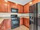 A well-appointed kitchen with dark wood cabinets, tile flooring, and stainless steel appliances at 11936 Esty Way, Carmel, IN 46033