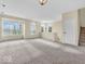 Large open living area with plush carpeting, large windows, and a view of the staircase at 11936 Esty Way, Carmel, IN 46033