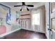 A charming bedroom featuring hardwood floors and a unique painted mural at 1208 W 8Th St, Anderson, IN 46016