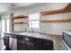 This kitchen features open wood shelving, subway tile backsplash and concrete counters at 1208 W 8Th St, Anderson, IN 46016