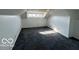 Finished attic space with gray carpeted floors, white walls and a window at 1342 W 18Th St, Indianapolis, IN 46202