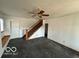 Open living room with staircase, large windows and a ceiling fan at 1342 W 18Th St, Indianapolis, IN 46202