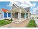 Inviting home featuring a covered front porch, gray siding, crisp white trim, and an eye-catching turquoise front door at 1804 Spann Ave, Indianapolis, IN 46203