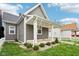 Beautifully landscaped home featuring a quaint front porch, gray siding, and well-manicured landscaping at 1804 Spann Ave, Indianapolis, IN 46203