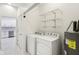 Bright laundry room with washer, dryer, and shelving for optimal storage space at 1804 Spann Ave, Indianapolis, IN 46203