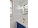 Bright bathroom featuring white square tiling, a blue vanity, and a round mirror with gold frame at 2830 Moller Rd, Indianapolis, IN 46224