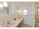 Bright bathroom featuring double sinks, neutral tiling, and a window providing natural light at 2830 Moller Rd, Indianapolis, IN 46224