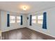 Cozy bedroom showcasing two windows with blue curtains and hard wood flooring at 2830 Moller Rd, Indianapolis, IN 46224