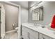 Bathroom features vanity with white cabinets and hard surface countertop with access to toilet and shower at 319 E 16Th E St # 201, Indianapolis, IN 46202