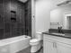 Modern bathroom with white vanity, black countertop, and tiled shower with recessed shelf at 319 E 16Th St # 302, Indianapolis, IN 46202
