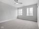 Carpeted bedroom with a ceiling fan, neutral decor, and windows that allow ample natural light at 319 E 16Th St # 302, Indianapolis, IN 46202