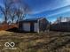 Metal shed with garage door and additional entrance in fenced backyard at 3337 Nottingham Dr, Columbus, IN 47203