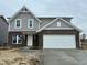Two story home with gray siding and a two car garage with black brick at the bottom at 335 Atlas Dr, Lebanon, IN 46052