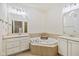 Bright bathroom with double sinks, large mirrors, soaking tub and neutral tile at 355 E Ohio E St # 206, Indianapolis, IN 46204