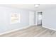 Bright, airy bedroom with modern laminate flooring and a window overlooking the front yard at 4123 S Lynhurst Dr, Indianapolis, IN 46221