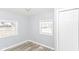 A bright bedroom with two windows, light gray walls, and a closet with white doors at 4123 S Lynhurst Dr, Indianapolis, IN 46221