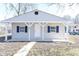 Charming home featuring blue shutters, a covered porch and updated neutral siding in a residential neighborhood at 4123 S Lynhurst Dr, Indianapolis, IN 46221