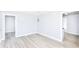 View of the living room with neutral paint, laminate flooring and multiple doorways at 4123 S Lynhurst Dr, Indianapolis, IN 46221
