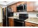 Kitchen features sleek black appliances, granite countertops, backsplash and wood cabinets at 4264 Foxglove Trce, Indianapolis, IN 46237