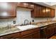 Kitchen sink with granite countertops, wood cabinets, and backsplash at 4264 Foxglove Trce, Indianapolis, IN 46237