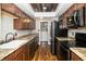 Open kitchen with modern appliances, wood cabinets, granite countertops, and wood-look flooring at 4264 Foxglove Trce, Indianapolis, IN 46237
