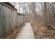 Exterior shot of the concrete walkway with a light post and a wood fence, leading to the building through bare trees at 4264 Foxglove Trce, Indianapolis, IN 46237