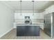 Well-lit kitchen featuring white cabinets, stainless steel appliances, and a spacious island at 4408 W Preserve Pass, New Palestine, IN 46163