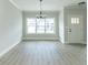 Bright living room featuring gray flooring, a large window, and a stylish chandelier at 4408 W Preserve Pass, New Palestine, IN 46163
