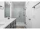 Bathroom features gray cabinets, quartz counters, black hardware, and a glass enclosed shower at 447 Leota St, Indianapolis, IN 46203