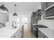 Modern kitchen features gray cabinets, stainless steel appliances, quartz counters, and an island with a sink at 447 Leota St, Indianapolis, IN 46203