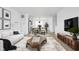 Inviting living room with stylish furniture, a decorative rug, and an open layout leading to the kitchen and dining area at 447 Leota St, Indianapolis, IN 46203
