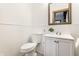 Cozy bathroom featuring a white toilet, vanity and framed mirror over neutral flooring at 4644 Cornelius Ave, Indianapolis, IN 46208