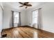 Bright bedroom with hardwood floors, ceiling fan, and two windows with views at 4644 Cornelius Ave, Indianapolis, IN 46208