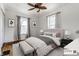 Virtually staged bedroom with hardwood floors, ceiling fan, and two windows at 4644 Cornelius Ave, Indianapolis, IN 46208