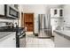 Bright kitchen showcasing stainless steel appliances and white cabinets, with tile floors and wood trim at 4644 Cornelius Ave, Indianapolis, IN 46208