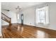 Bright living room featuring a wooden staircase, large window, and hardwood floors at 4644 Cornelius Ave, Indianapolis, IN 46208