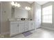 Well-lit bathroom featuring a double vanity with framed mirror and white cabinets at 517 Steinbeck Pl, Carmel, IN 46032