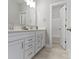 Bright bathroom with a double vanity, white cabinets, and tile floors at 517 Steinbeck Pl, Carmel, IN 46032