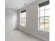 Neutral bedroom featuring carpet, white trim, two windows and a white door at 517 Steinbeck Pl, Carmel, IN 46032