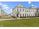 Inviting townhome with a well-maintained lawn, complemented by black wrought iron fence and sidewalk at 517 Steinbeck Pl, Carmel, IN 46032