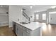 Open kitchen layout with island and stairs, showcasing natural light and modern finishes at 517 Steinbeck Pl, Carmel, IN 46032
