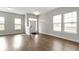 Bright living room featuring hardwood floors and ample natural light through multiple windows at 517 Steinbeck Pl, Carmel, IN 46032