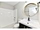Modern bathroom featuring a vanity with a round mirror, and a shower-tub combo at 6251 Kelsey Dr, Indianapolis, IN 46268