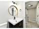 Bright bathroom vanity with a sleek round mirror, and a black faucet fixture at 6251 Kelsey Dr, Indianapolis, IN 46268