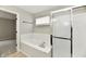 Bathroom featuring a soaking tub, glass-enclosed shower, and neutral tile surround at 6251 Kelsey Dr, Indianapolis, IN 46268