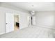 Spacious bedroom with neutral paint, carpet, and open doors to the bathroom and closet at 6251 Kelsey Dr, Indianapolis, IN 46268