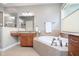 Bright bathroom featuring double sinks, a large soaking tub, and tiled flooring at 651 Greenford N Trl, Carmel, IN 46032